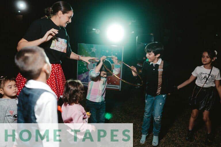 Children and adult playing with a hoop outdoors at night