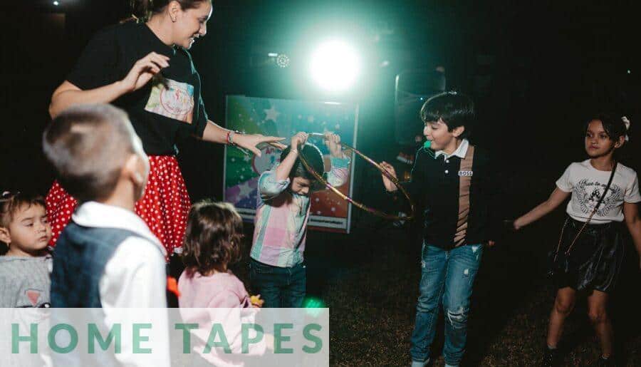 Children and adult playing with a hoop outdoors at night