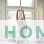 woman sitting on white bed while stretching