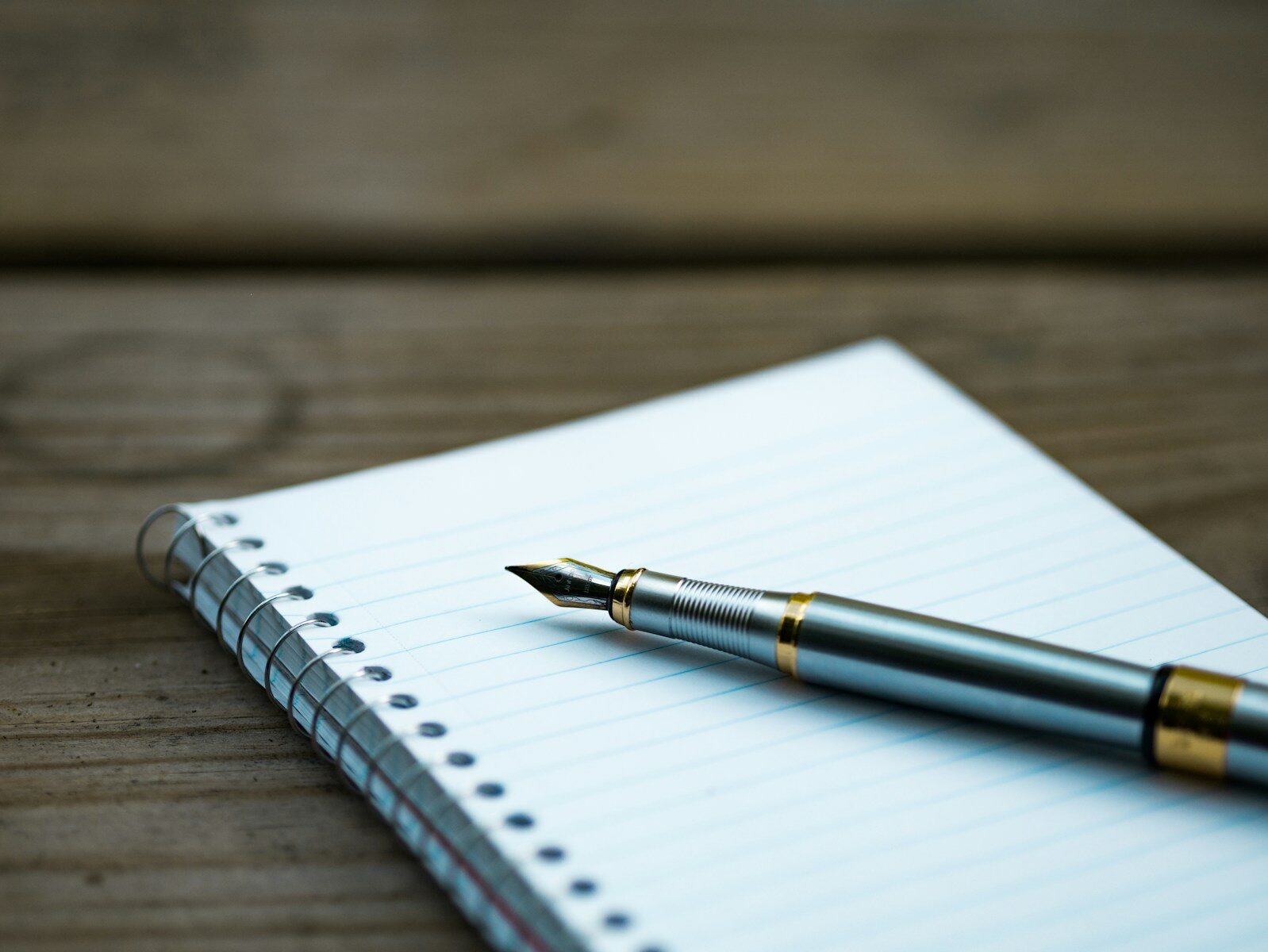 Cuaderno abierto con una pluma estilográfica sobre un escritorio